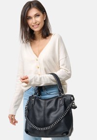 Zwarte leren handtas met een gestructureerd oppervlak, dubbele handvatten bovenaan en een kettingaccent. Zachte, gestructureerde vorm, geschikt voor dagelijks gebruik.