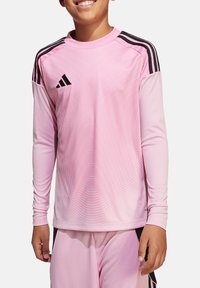 Maglia sportiva a maniche lunghe rosa con accenti neri e logo Adidas, caratterizzata da un motivo testurizzato e un design aderente.