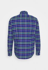 Chemise à manches longues en coton avec un motif à carreaux bleu, vert et blanc. Dispose d'un col classique et de poignets boutonnés. Vue de dos.