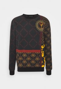 Sort sweatshirt med forskellige mønstre i guld og rød. Har et cirkulært design og detaljerede kanter, ribkantede ærmer og rund hals.