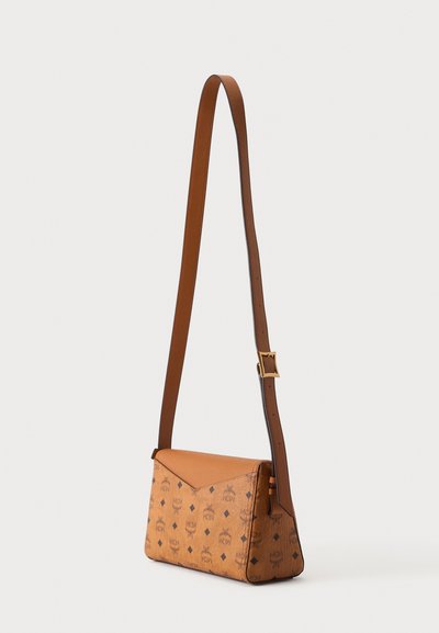 Sac bandoulière rectangulaire couleur cannelle avec sangle marron ajustable et motif logo noir sur le corps principal sur fond clair.