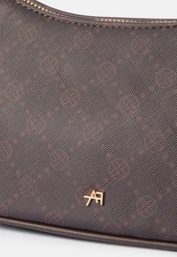 Rudas raštuotas maišelis su tekstūruota medžiaga, puikuojantis auksiniu "AA" logotipu. Užtrauktuko uždarymas ir lygios medžiagos pagerina jo dizainą.