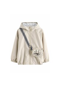 Coupe-vent beige avec capuche grise, fermeture éclair à l'avant, sangle rayée noire et blanche, et une poche ornée d'un visage de lion avec des oreilles.