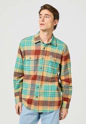Flanellen overhemd met een veelzijdig geruit patroon in teal, geel, bruin en blauw. Voorzien van een knoopsluiting aan de voorkant en twee borstzakken.