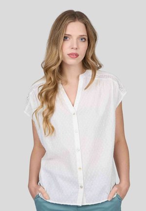 Chemisier blanc à manches courtes, motif à pois texturé et fermeture à boutons sur le devant. Détails en dentelle sur les épaules et coupe décontractée.