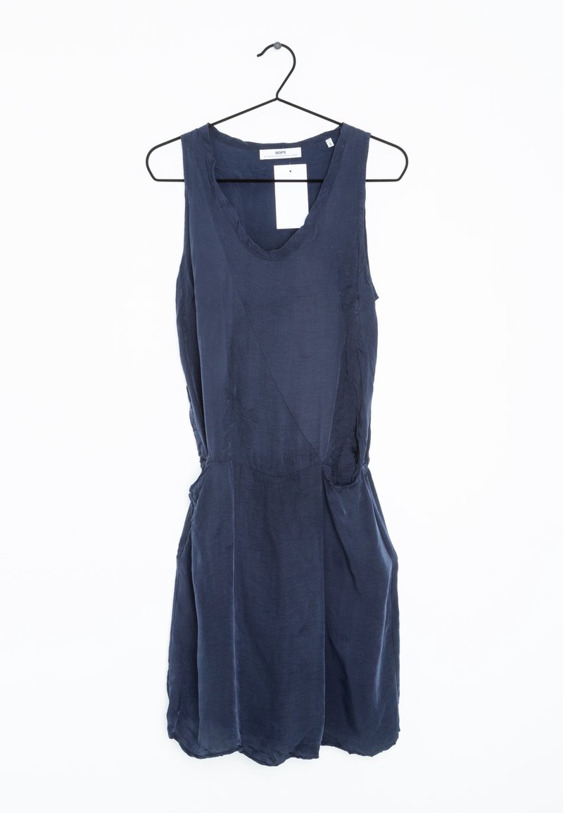 Robe sans manches bleu foncé avec un col rond, suspendue à un cintre en fil noir sur un fond blanc.