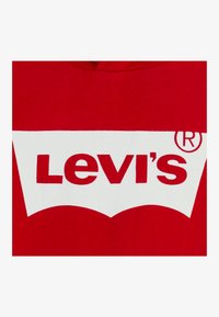 Felpa rossa in cotone con un grande logo bianco Levi's in un design curvo accompagnato dal simbolo di marchio, al centro davanti, su una superficie liscia.