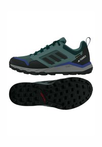 Grüne und schwarze Adidas Terrex Wanderschuhe mit robusten schwarzen Sohlen, Gore-Tex-Label und Traxion-Profil für optimalen Halt im Freien.