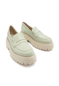 Jasnozielone skórzane loafersy z grubą, kremową podeszwą platformową i subtelnymi detalami na cholewce. Gładka faktura na całej powierzchni.