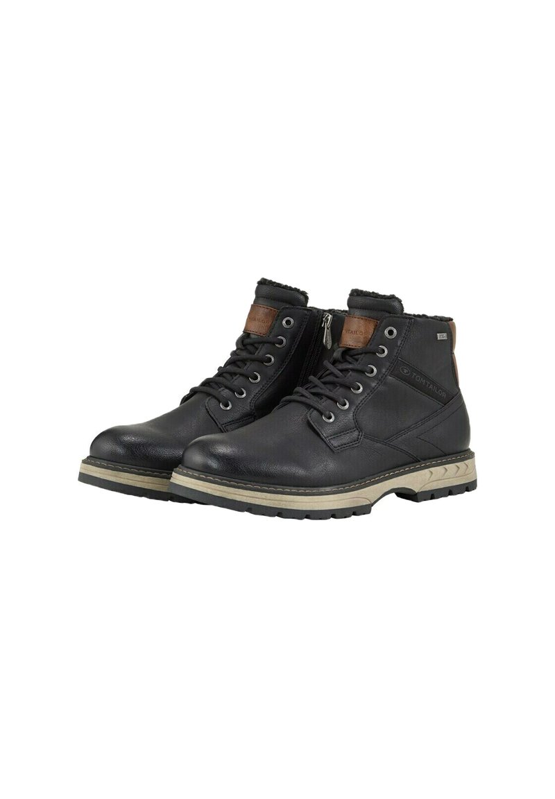 Botas de tobillo de cuero negro con cordones, suelas de goma beige, cremallera lateral y acentos marrones en el cuello y la lengua.