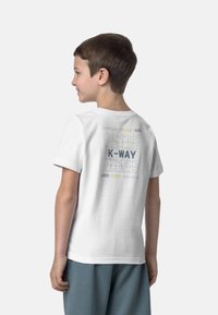 T-shirt in cotone bianco con un design grafico sul retro con la scritta "K-WAY" e testo colorato, maniche corte e colletto tondo.