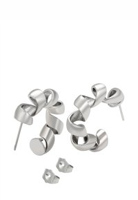 Twistede sølvøreringe med en glat, blank finish og to separate sommerfuglbakkeringe på en hvid baggrund.