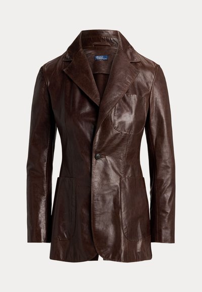 Καφέ δερμάτινο σακάκι με γιακά με εγκοπές, δύο εμπρόσθιες τσέπες και κούμπωμα με ένα κουμπί. Ομαλή υφή με ημιγυαλιστερή επιφάνεια.
