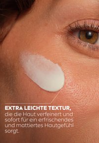 Creamy moisturizer applied to skin, with a smooth, white texture on tan skin, highlighting a matte finish and enhancing skin appearance.