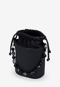 Bolso de hombro negro de cuero con parte superior ajustable mediante cordón. Presenta una superficie texturada y una correa decorativa de cuentas en negro y gris.