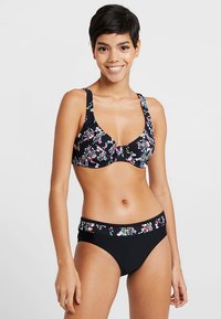 Svart bikini med ett blommönster i rosa, blått och grönt. Toppen har en tvistdesign; botten har en mönstrad midja. Slät textur.