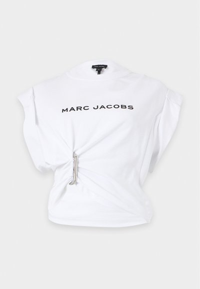 Top sans manches blanc Marc Jacobs avec texte du logo noir et détail d'épingle à nourrice argentée resserrant le tissu à la taille gauche.