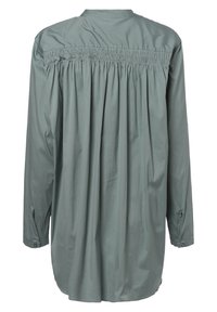 Camicia a maniche lunghe in morbido tessuto verde, con dettagli arricciati sulle spalle e polsini con bottoni. Vestibilità ampia e rilassata.