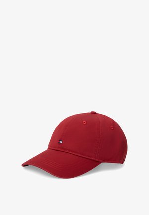 Punane pesapalli nokamüts, valmistatud siledast kangast, millel on kõver nokk ja esiküljel väike tikandiga sinise, valge ja punase värviga logo.