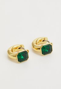 Boucles d'oreilles en or en forme d'anneau, mettant en vedette un bijou vert octagonal, avec un fini métallique lisse et un mécanisme de fermeture sécurisé.