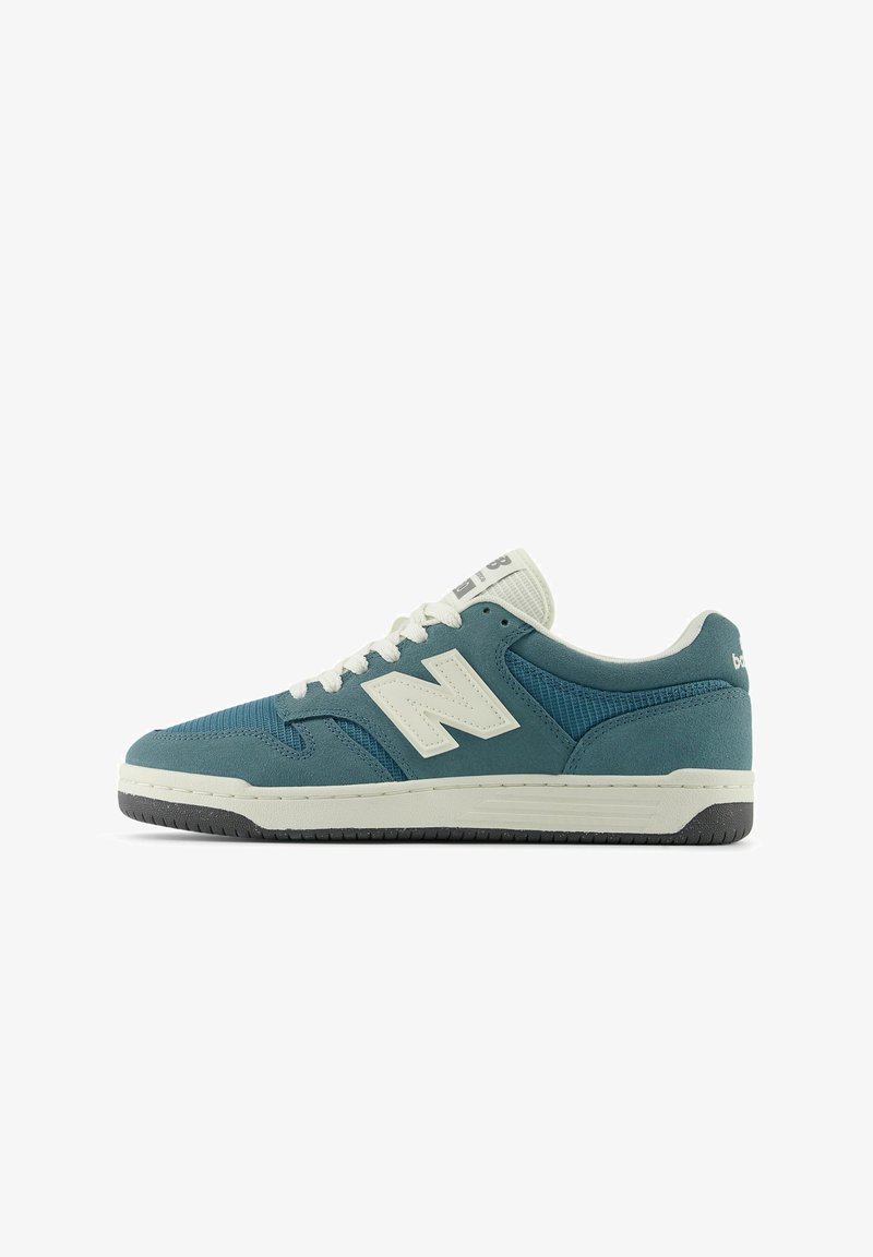 Baskets New Balance basses bleu sarcelle et blanches avec des panneaux en mesh et en suède, des lacets blancs et une semelle noire et blanche.