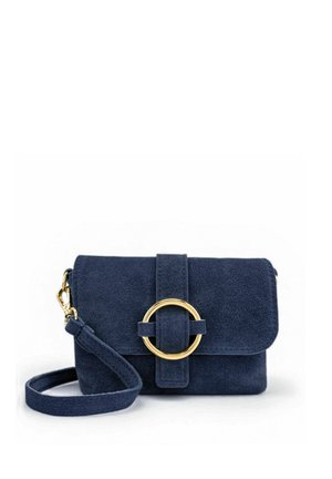 Petit sac à main en daim bleu marine avec bandoulière réglable et grande boucle circulaire dorée sur le rabat avant.