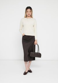 Cream knitted sweater, brown fitted skirt with side slit, dark brown handbag, and glossy burgundy flats. Simple, clean aesthetic.