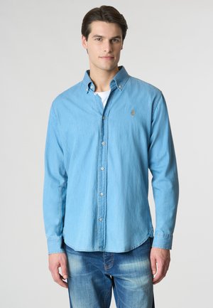 Camicia azzurra a maniche lunghe con colletto, caratterizzata da un piccolo logo ricamato sul petto e orlo dritto.