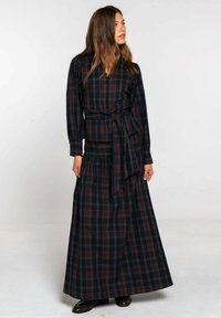 Robe longue à carreaux en bleu marine et bordeaux. Dotée d'une taille cintrée avec un nœud, de manches longues et d'une jupe évasée. Texture lisse.