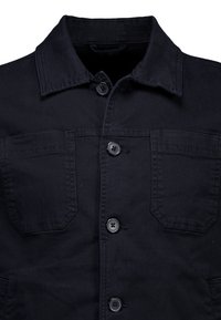 Giacca in denim nero con colletto, chiusura frontale con bottoni e due tasche sul petto con dettagli applicati. Tessuto liscio, materiale resistente.