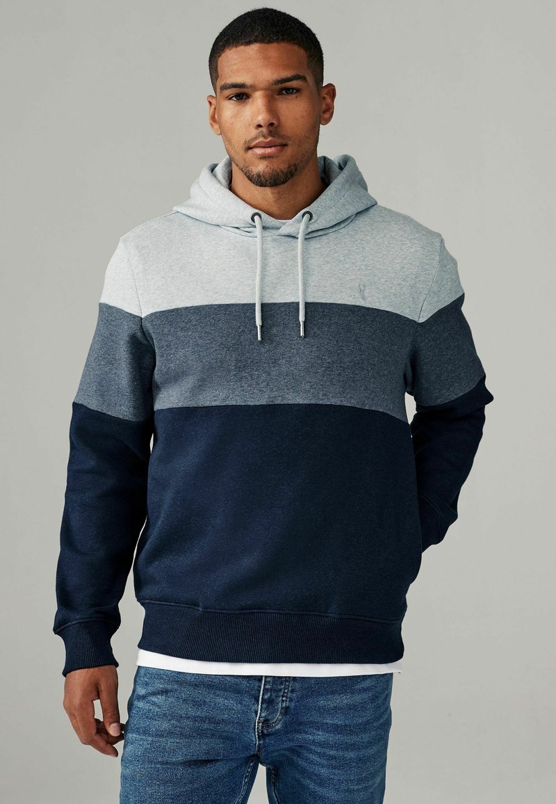Hoodie met een kleurblokontwerp in lichtgrijs, marineblauw en donkerblauw. Voorzien van ribgebreide manchetten en zoom, en details met een trekkoord.
