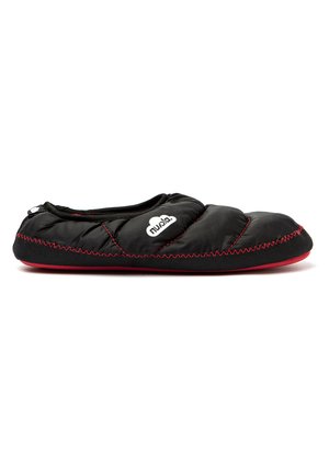 Zapatilla negra acolchonada con costuras y suela rojas. Diseño redondeado, textura suave y un logo en el lateral. Adecuada para uso en interiores.