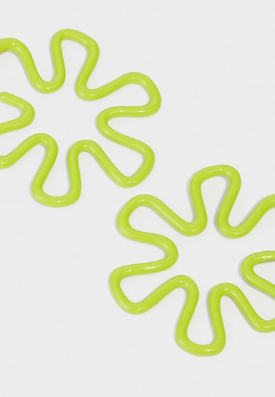 Grüne Kunststoffhaarklammern mit welligen, sternförmigen Designs. Glatte Textur mit glänzendem Finish, in einer hellen Neonfarbe.