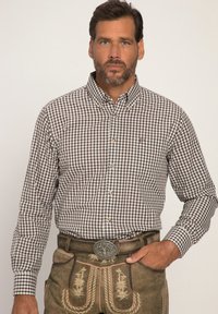 Braun-weiße karierte Langarmbluse mit Button-Down-Kragen, kombiniert mit dekorativen Ledershorts und einer Metall-Gürtelschnalle.