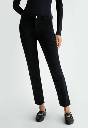 Pantaloni in corduroy neri con una vestibilità slim, forma dritta, tasche frontali e chiusura con bottone. Texture morbida con una leggera lucentezza.