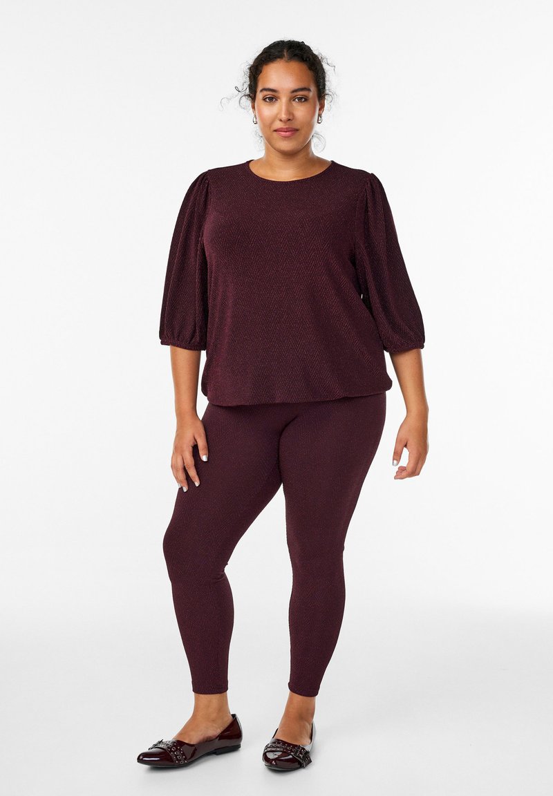 Top borgogna testurizzato con maniche a sbuffo abbinato a leggings coordinati, completato da ballerine borgognone lucide con hardware decorativo.