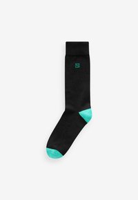 Black sock with a turquoise accent at the toe and heel. Features a green logo emblem near the cuff. Smooth texture and standard length.