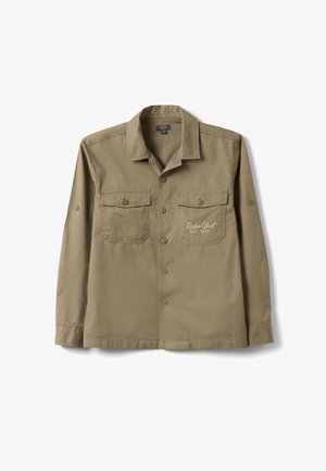 Khaki long-sleeve shirt with collar, button front, two buttoned chest pockets, and "Rider Unit EST. 1986" text on the right pocket.