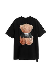 Camiseta negra con un diseño de osito de peluche naranja y difuso en la parte trasera, con detalles negros en su cuerpo y acentos de goteo en blanco.