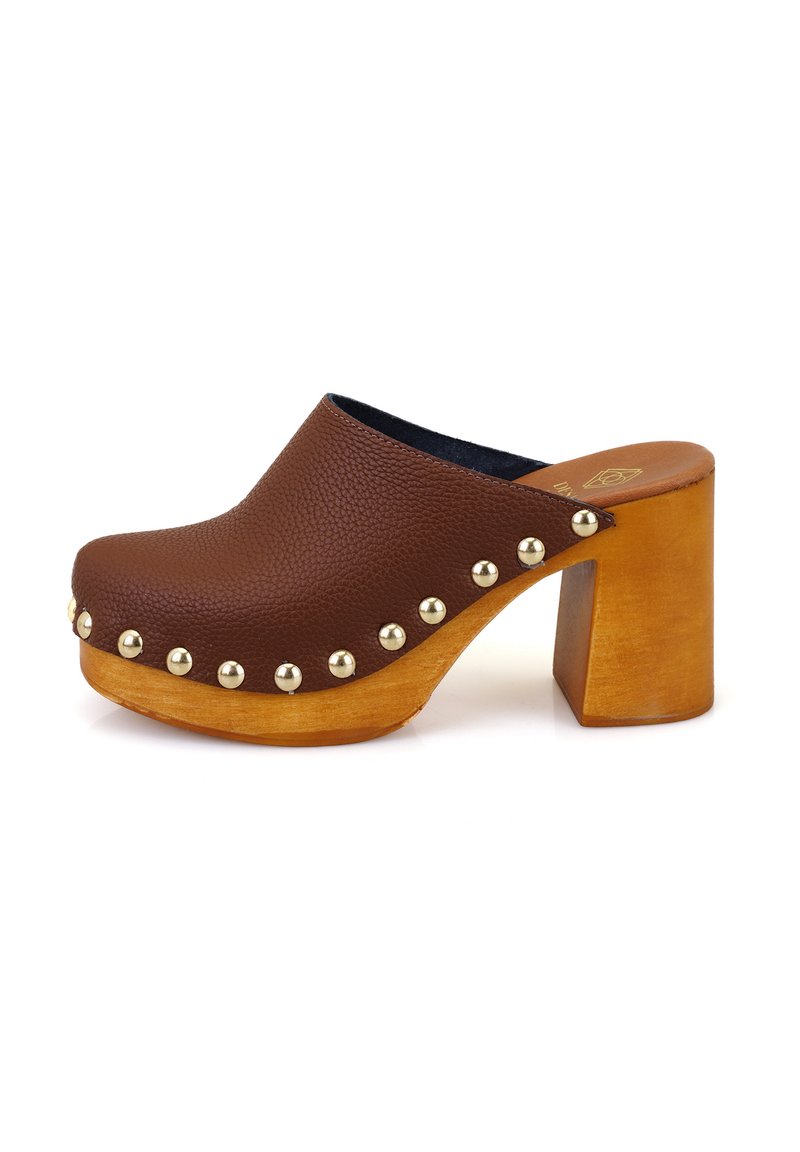Sabot en cuir brun avec un bout rond, des clous dorés sur le côté et un talon en bois épais. Dessus texturé avec une finition lisse à la base.