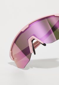 Occhiali da sole sportivi con montatura rosa, lenti a specchio viola e verdi, e un design angolare unico. Inclusi cuscinetti nasali neri regolabili.