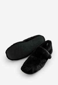 Czarne, puszyste kapcie z płaską podeszwą, z paskiem na górze i miękką fakturą. Podeszwa ma teksturowane, trwałe wykończenie.