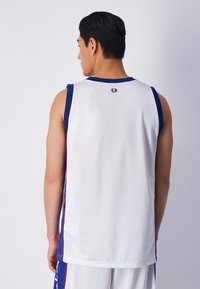 Jersey atlético blanco con acentos en azul y rojo. Diseño sin mangas, textura suave, caída ligera, con un pequeño logotipo en la parte posterior.