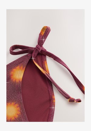 Burgundové horní díl plavek se zavazovacími ramínky, zdobený motivem sluneční záře v oranžové a žluté barvě. Texturovaná látka s mírným leskem.