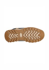 La semelle de la chaussure présente un motif de bande de roulement ondulé avec une combinaison de caoutchouc beige et marron. Surface texturée pour une meilleure adhérence. Découpe ovale au centre.