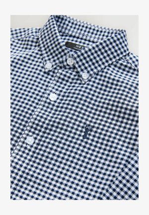 Srajca z gumbi v mornarsko modri in beli karirasti vzorci, izdelana iz bombaža. Ima ovratnik, bele gumbe in subtilno vezeno logo.