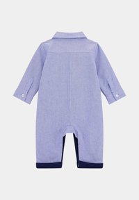 Romper azzurro chiaro realizzato in tessuto morbido con maniche lunghe, colletto e polsini navy alle caviglie e alle maniche. Presenta dettagli con bottoni.