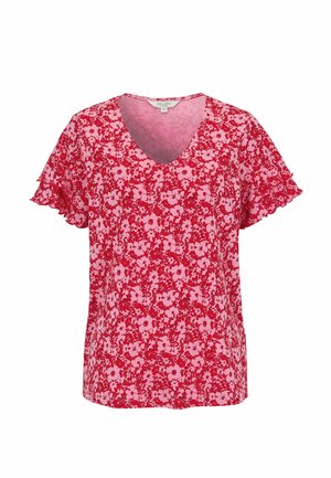 Punainen ja vaaleanpunainen kukallinen lyhythihainen pusero, jossa V-aukko ja kevyet röyhelöt hihansuissa, valkoista taustaa vasten.