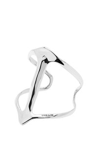 Anillo escultórico de plata con un diseño fluido y alargado. Superficie lisa, espacios abiertos y formas únicas que crean una estética moderna.