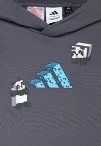 Sweat à capuche gris avec un design Minecraft représentant deux pandas pixélisés et des structures bleues en blocs. Le sweat présente une finition en tissu texturé.